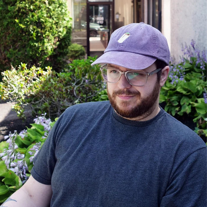 Image of man wearing purple dad hat with embroidered burrito