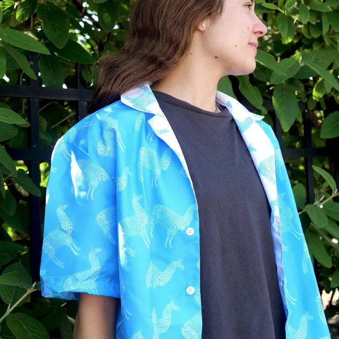Person wearing a blue llama patterned shirt outdoors