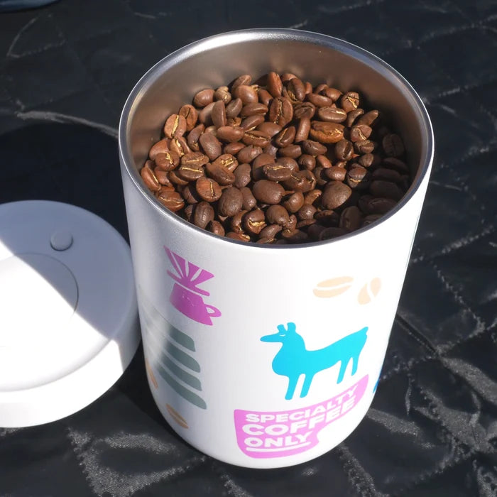 Reserve canister filled with coffee beans on a dark textured surface